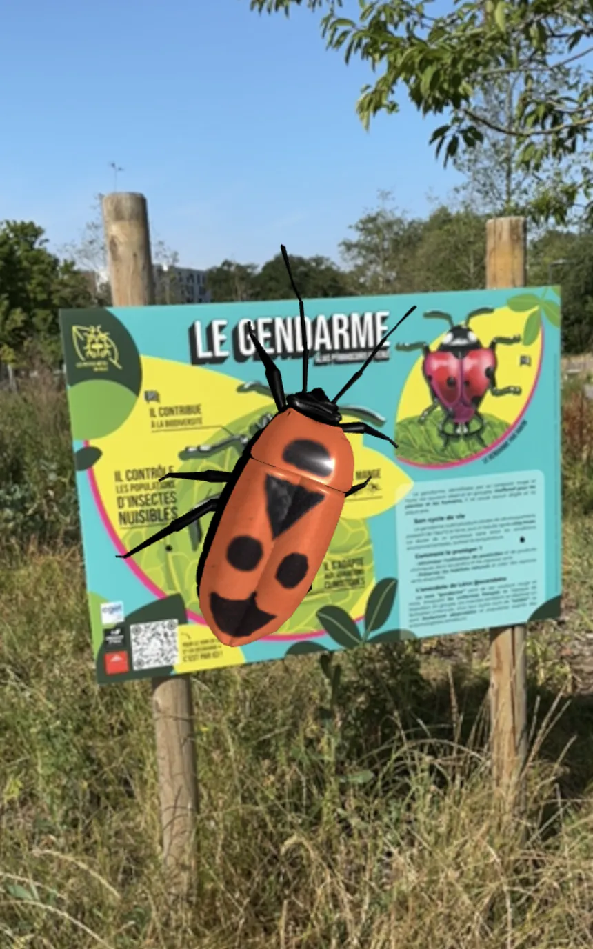 Un gendarme en réalité augmentée devant un panneau Les petites bêtes en ville.